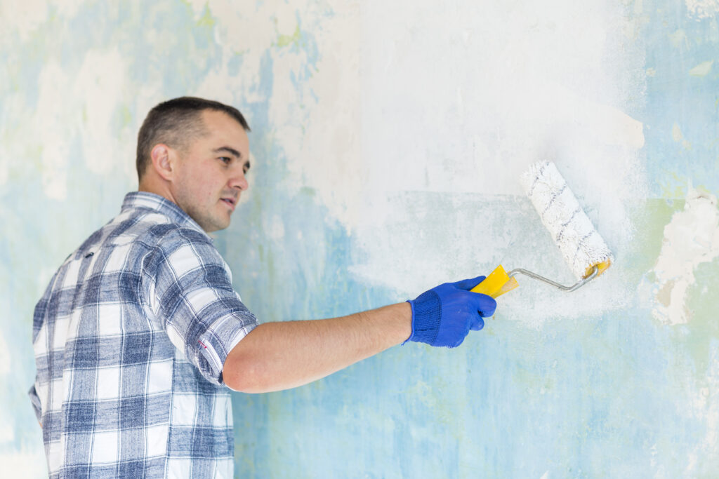 man working wall with paint roller man working wall with paint roller